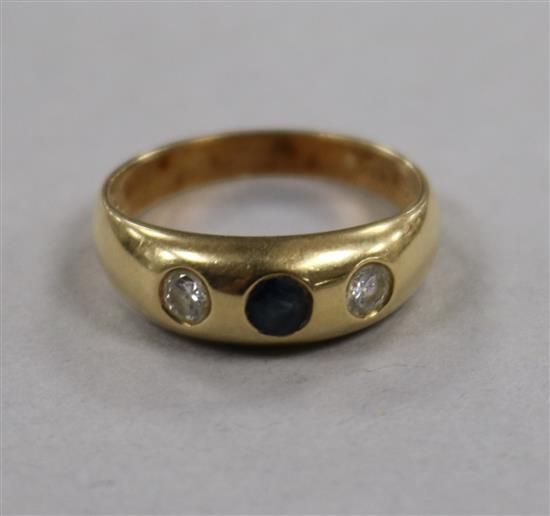 A 14ct gold and gypsy set three stone sapphire and diamond ring, size M.